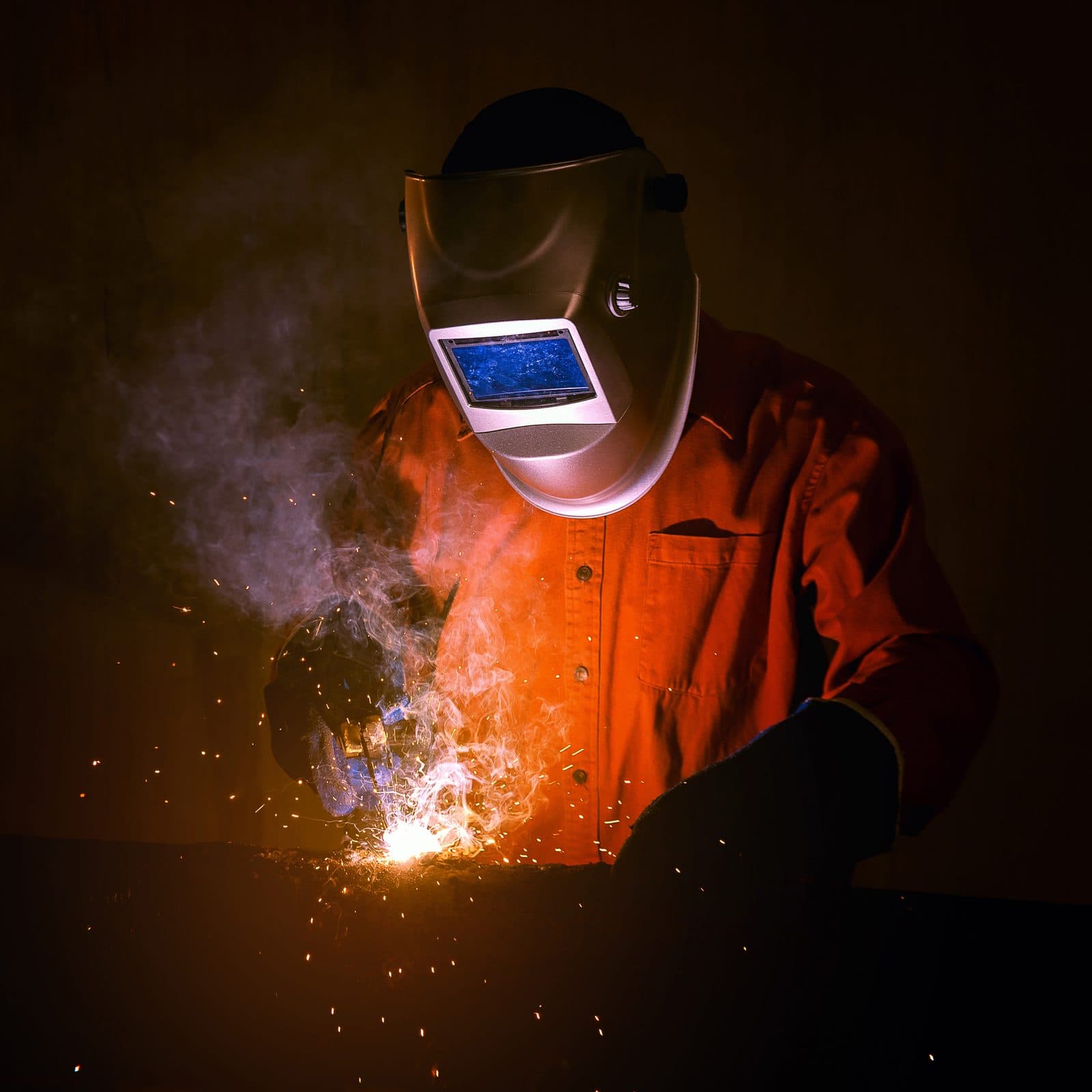 Industrial welder working on structural steel under AWS D1.1