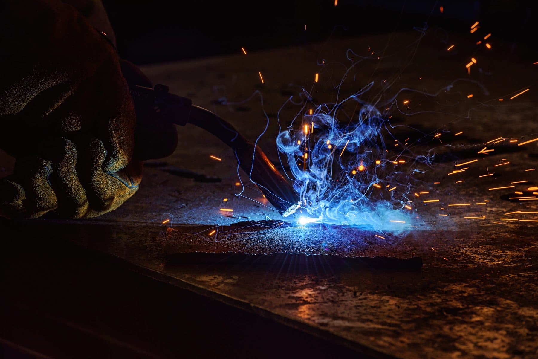 Close-up of welder brazing metal, sparks flying